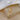 Gold-tone butterfly tassel necklace lying in an open jewelry box beside white fabric